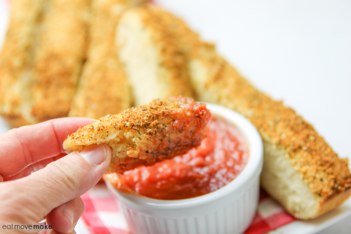 dipping homemade breadsticks in marinara sauce