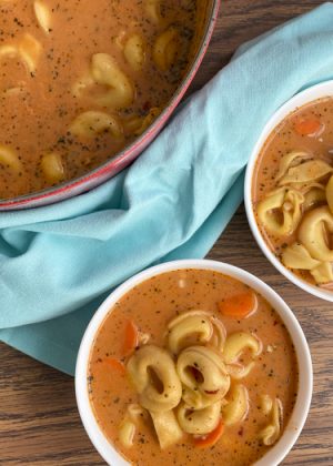 tomato tortellini soup in bowls and in the pot