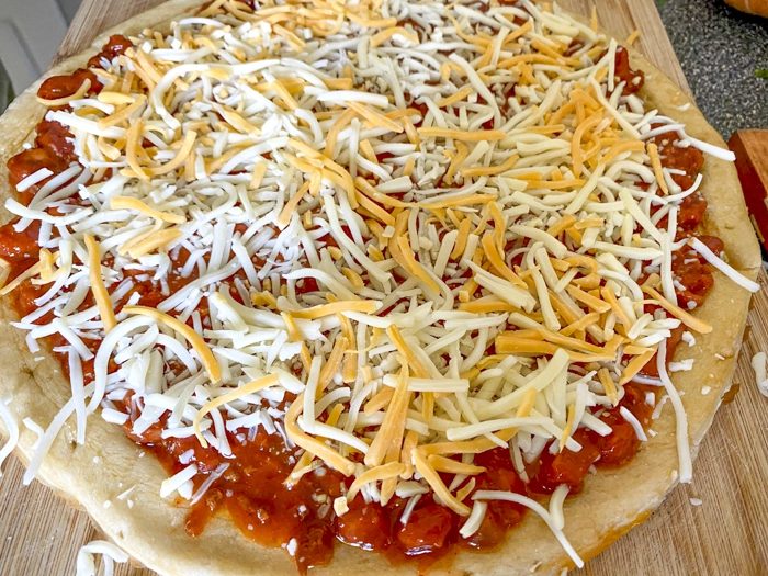 add shredded cheese to pizza