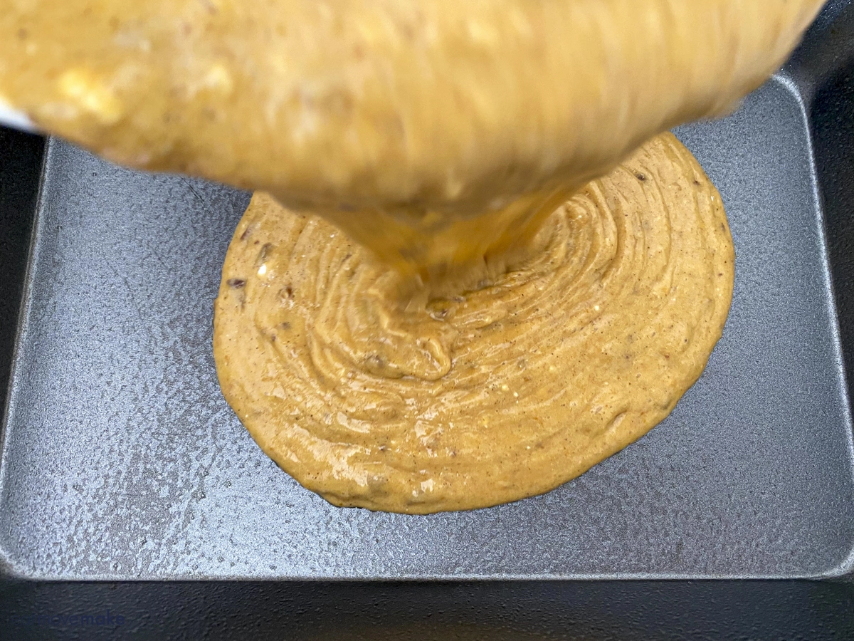 pouring cake batter into greased pan