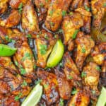 Asian chicken wings on baking sheet with limes