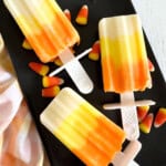 candy corn pudding bars with candy corn on black tray.
