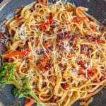 sun-dried tomato pasta in pan with Parmesan cheese sprinkled.